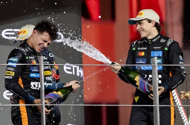 ABU DHABI Lando Norris (McLaren) celebrates his third-place finish and the world title on the podium at the Yas Marina Circuit after the Abu Dhabi Grand Prix. On the right is Oscar Piastri (McLaren), who finished second. ANP SANDER KONING xVIxANPxSportx xxANPxIVx 544187928 originalFilename: 544187928.jpg