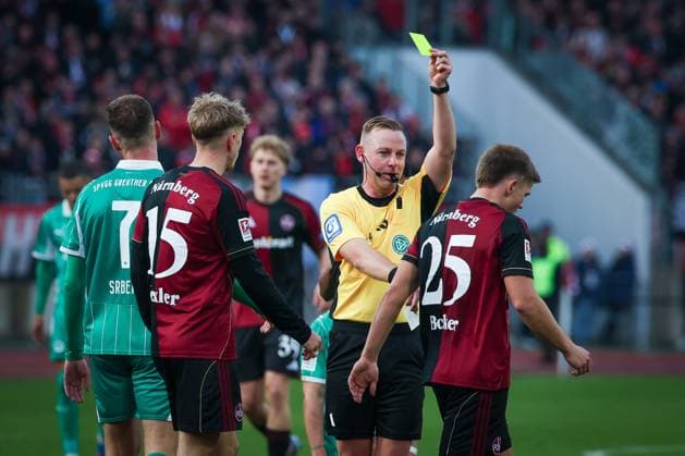 Yellow card for Finn Becker 25 1FC Nuernberg by Referee Referee Lars Erbst after a foul, 1 FC Nuernberg vs Spvgg Greuther Fuerth, Football, 2 Bundesliga, DFL, Season 2025 2026, Hinrunde, 15 Spieltag, 07 12 2025 DFB regulations prohibit any use of photographs as image sequences and or quasi video Nuernberg Bayern Germany Copyright: xkolbert-press MartinxAgüerax