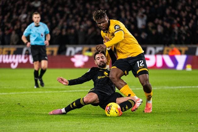 8th December 2025; Molineux Stadium, Wolverhampton, West Midlands, England; Premier League Football, Wolverhampton Wanderers versus Manchester United, ManU Bruno Fernandes of Manchester United scores on the ground under the challenge from Emmanuel Agbadou of Wolverhampton Wanderers in the 25th minute to make the score 0-1  GodfreyxPitt