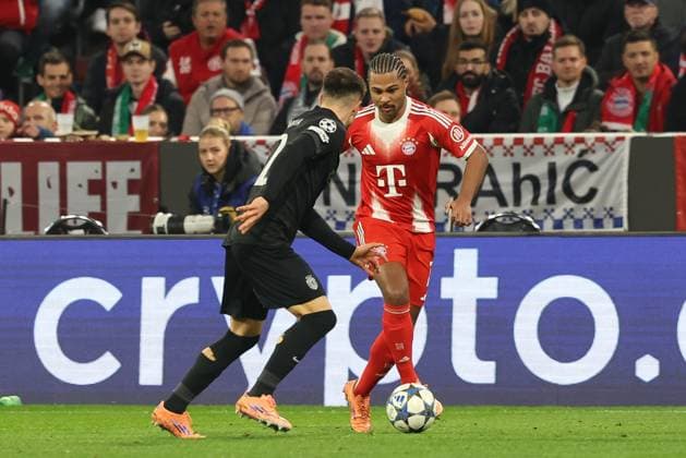 in duel, action, with Ivan Fresneda 22 Sporting Lisbon , Serge Gnabry 7 FC Bayern Muenchen , FC Bayern Muenchen vs Sporting Lisbon, Soccer, Champions League, Matchday 6, 09 12 2025 Muenchen Bayern Germany Copyright: xkolbert-press ChristianxKolbertx