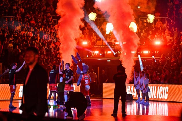 GER, BBL, ratiopharm Ulm vs Rasta Vechta 13 12 2025, ratiopharm arena, Neu Ulm, GER, BBL, ratiopharm Ulm vs Rasta Vechta, in the picture Ulm players are greeted with light effects and fog in the hall, Teo Milicic Ulm, 44 , the Ulm mascot Spass has a Christmas hat to match the Christmas game nordphotoxGmbHx xHafner nph00200