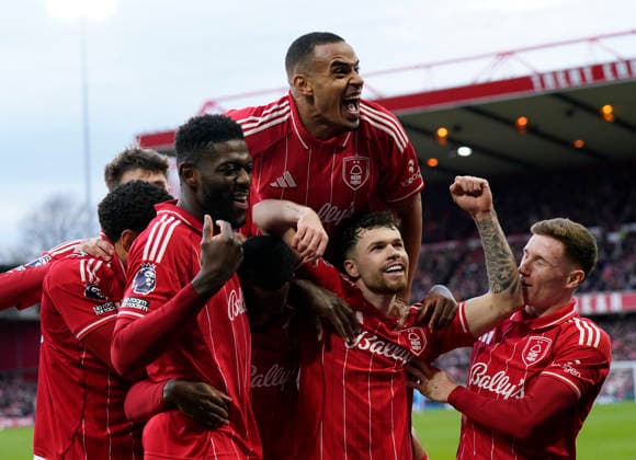 Nottingham, England, 14th December 2025. Callum Hudson-Odoi of Nottingham Forest is mobbed as he celebrates scoring their second goal with Murillo of Nottingham Forest jumping over the top during the Nottingham Forest vs Tottenham Hotspur Premier League match at the City Ground, Nottingham. Picture credit should read: Andrew Yates Sportimage EDITORIAL USE ONLY. No use with unauthorised audio, video, data, fixture lists, club league logos or live services. Online in-match use limited to 120 images, no video emulation. No use in betting, games or single club league player publications. SPI_050_AY_Forest_Spurs SPI-4376-0052