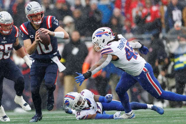 New England Patriots quarterback Drake Maye (L) avoids Buffalo Bills linebacker Shaq Thompson (R) during the first half at Gillette Stadium in Foxborough, Massachusetts on Sunday, December 14, 2025.  BOP20251214013 CJxGUNTHER