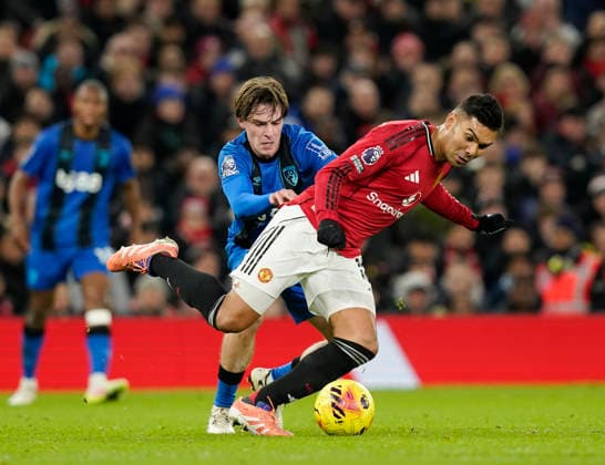 Manchester, England, 15th December 2025. Alex Scott of Bournemouth tackles Casemiro of Manchester United, ManU during the Manchester United vs AFC Bournemouth Premier League match at Old Trafford, Manchester. Picture credit should read: Andrew Yates Sportimage EDITORIAL USE ONLY. No use with unauthorised audio, video, data, fixture lists, club league logos or live services. Online in-match use limited to 120 images, no video emulation. No use in betting, games or single club league player publications. SPI_040_AY_Man_Utd_Bmouth SPI-4379-0040