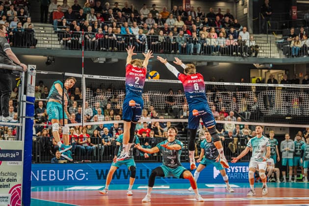 Volleyball mens season 2025 2026 Zoi DVV Cup semi-final SVG Lüneburg vs SWD powervolleys Düren 16 12 2025 Jordan Canham 7 SWD powervolleys Düren against the block of Daniel Gruvaeus 2 SVG Lüneburg and Jackson Howe 6 SVG Lüneburg