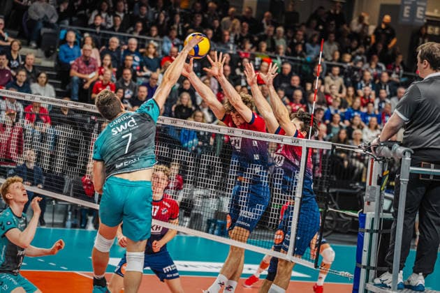 Volleyball mens season 2025 2026 Zoi DVV Cup semi-final SVG Lüneburg vs SWD powervolleys Düren 16 12 2025 Jordan Canham 7 SWD powervolleys Düren against the block of Joscha Kunstmann 7 SVG Lüneburg and Ethan Champlin 20 SVG Lüneburg
