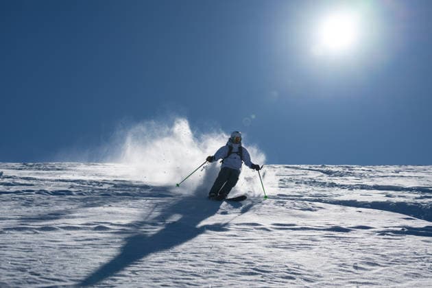 Ein Skifahrer fährt abseits der Piste durch frischen Pulverschnee an einem sonnigen Berghang und wirbelt bei der Abfahrt Schnee auf, wodurch eine dynamische und energiegeladene Wintersport-Action-Szene unter einem klaren blauen Himmel entsteht Skier skiing off piste through fresh powder on a sunny mountain slope, kicking up snow as she descends, creating a dynamic and energetic winter sports action scene under a clear blue sky. (License=RF) 24319116 ,model released, Symbolfoto Copyright: xZoonar.com benisxarapovicx 24319116 ,model released, Symbolfoto ,property released