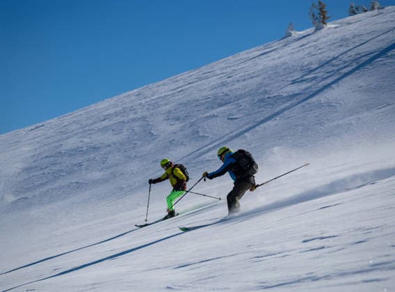 Drei Skifahrer sausen einen sonnigen, mit Pulverschnee bedeckten Berghang hinunter, wobei sie unter einem strahlend blauen Himmel frischen Schnee aufwirbeln, was eine dynamische Wintersport-Action-Szene ergibt. Three skiers carve down a sunny, powder-covered mountain slope, kicking up fresh snow under a clear blue sky, creating a dynamic winter sports action scene. (License=RF) 24319131 ,model released, Symbolfoto Copyright: xZoonar.com benisxarapovicx 24319131 ,model released, Symbolfoto ,property released