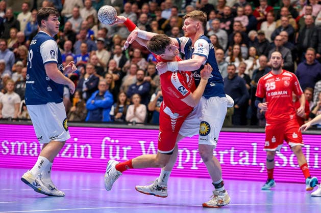 18.12.2025, Handball, Viertelfinale DHB-Pokal, Bergischer HC - MT Melsungen, Unihalle Wuppertal: Nikolaj Enderleit (Melsungen 04) wird von Johannes Wasielewski (BHC 77) am Kreis fest gemacht Nordrhein-Westfalen Deutschland
