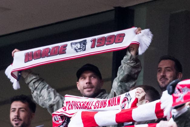 KOELN, GERMANY - DECEMBER 20: Lukas Podolski (former 1. FC Koeln player) holding up a scarf during the anthem before the Bundesliga match between 1. FC Koeln vs. 1. FC Union Berlin at Rheinenergie-Stadion on matchday 15 of the 1. Bundesliga on December 20, 2025 in Koeln, Germany. DFL REGULATIONS PROHIBIT ANY USE OF PHOTOGRAPHS AS IMAGE SEQUENCES AND OR QUASI-VIDEO. North Rhine Westphalia Germany Copyright: xSteffiexWunderlx