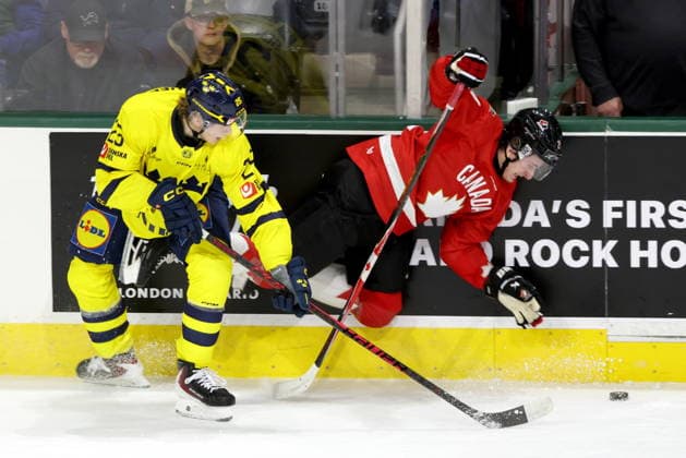 December 20, 2025, London, On, Canada: Sweden forward Eddie Genborg (25) checks Canada forward Cole Reschny (21) during the first period of a IIHF World Junior Hockey Championship pre-tournament game in London, Ont., Saturday, December 20, 2025. HKO-IIHF-Sweden-Canada 20251220  - ZUMAc35_ 20251220_zaf_c35_094 Copyright: xNicolexOsbornex