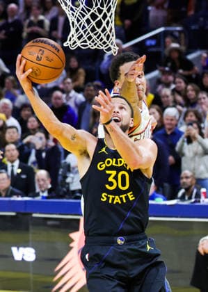 (251221) -- SAN FRANCISCO, Dec. 21, 2025 -- Stephen Curry (front) of Golden State Warriors goes for a layup during the 2025-2026 NBA, Basketball Herren, USA regular season game between Golden State Warriors and Phoenix Suns in San Francisco, the United States, Dec. 20, 2025. (Photo by Xinhua) (SP)U.S.-SAN FRANCISCO-BASKETBALL-NBA-WARRIORS VS SUNS DongxXudong 