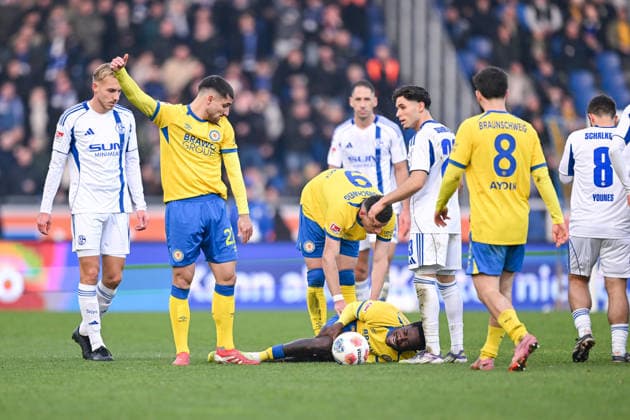 21 12 2025, Football, 2 Bundesliga, Season 2025 2026, Matchday 17, Eintracht Braunschweig FC Schalke 04, Joe Christian Conteh Eintracht Braunschweig lies injured on the ground and screams, xRHR PHOTO YYx Copyright: KROEGER RHR-FOTOx RHR-FOTO YY