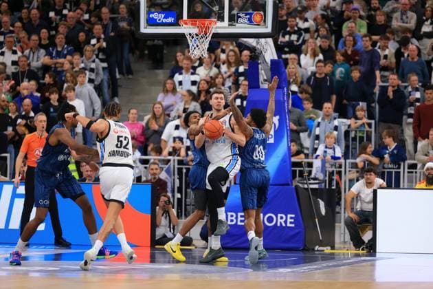Game action with 17 MLP Academics Heidelberg, Zacharie Perrin 52 Veolia Towers Hamburg and Nelson Martin 10 Veolia Towers Hamburg easyCredit BBL MLP Academics Heidelberg - Veolia Towers Hamburg 21 12 2025 SNP Dome Heidelberg 17 MLP Academics Heidelberg in action Copyright: xspeedshotx