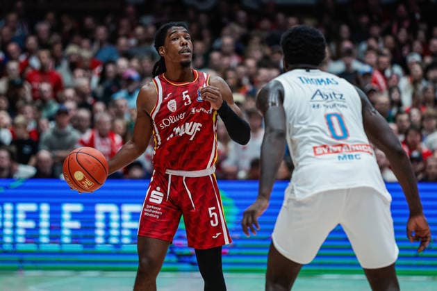 In the picture from left Marcus Carr Wuerzburg Baskets, 5 against Khyri Thomas Syntainics MBC, 0 21 12 2025, Basketball, Fitness First Wuerzburg Baskets vs SYNTAINICS MBC, easyCredit BBL, 11 Matchday, Germany, Wuerzburg, tectake Arena, Copyright: HMBxMedia xJulienxBecker