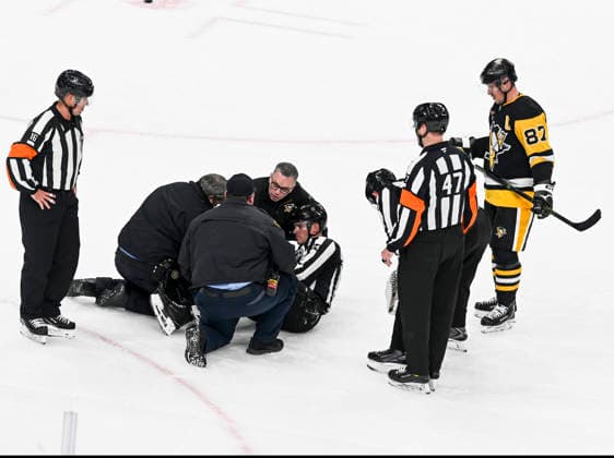 Paramedic comes to the aid of Linesperson Ryan Jackson (84) as Pittsburgh Penguins center Sidney Crosby (87) looks during the second period at PPG Paints Arena in Pittsburgh on Sunday, December 21, 2025.  PIT2025122110 ARCHIExCARPENTER