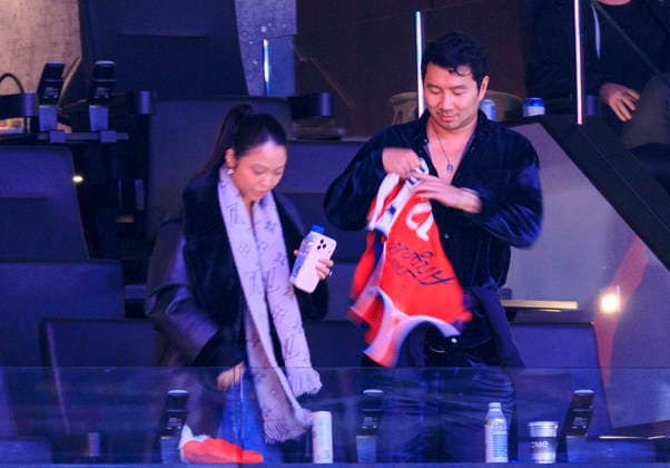 December 23, 2025, Inglewood, California, USA: Simu Liu (R) puts on a Clippers jersey as and Allison Hsu looks on during the 2025 NBA, Basketball Herren, USA regular season game between the Los Angeles Clippers and the Houston Rockets on Tuesday December 23, 2025 at Intuit Dome Arena in Inglewood, California. Clippers defeat Rockets, 128-108. JAVIER ROJAS PI Inglewood USA - ZUMAp124 20251223_zaa_p124_051 Copyright: xJavierxRojasx