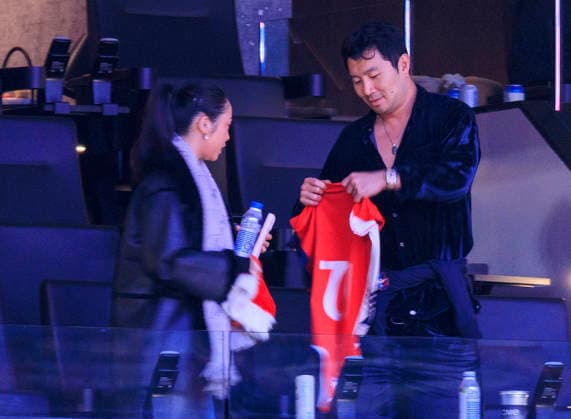 December 23, 2025, Inglewood, California, USA: Simu Liu (R) puts on a Clippers jersey as and Allison Hsu looks on during the 2025 NBA, Basketball Herren, USA regular season game between the Los Angeles Clippers and the Houston Rockets on Tuesday December 23, 2025 at Intuit Dome Arena in Inglewood, California. Clippers defeat Rockets, 128-108. JAVIER ROJAS PI Inglewood USA - ZUMAp124 20251223_zaa_p124_053 Copyright: xJavierxRojasx