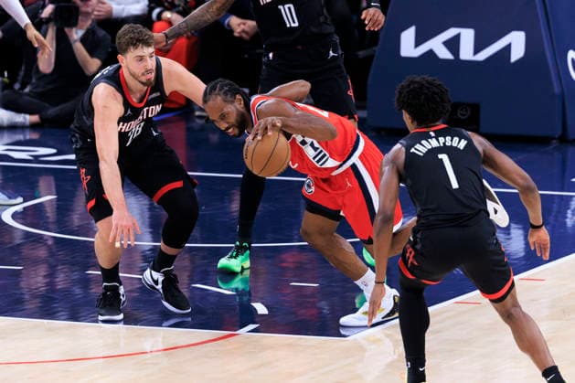 December 23, 2025, Inglewood, California, USA: Kawhi Leonard 2 of the Los Angeles Clippers trips as Alperen Sengun 28 and Amen Thompson 1 of the Houston Rockets attempt to steal the ball during their regular season NBA, Basketball Herren, USA game on Tuesday December 23, 2025 at Intuit Dome in Inglewood, California. Clippers defeat Rockets, 128-108. ARIANA RUIZ PI Inglewood USA - ZUMAp124 20251223_zaa_p124_068 Copyright: xArianaxRuizx