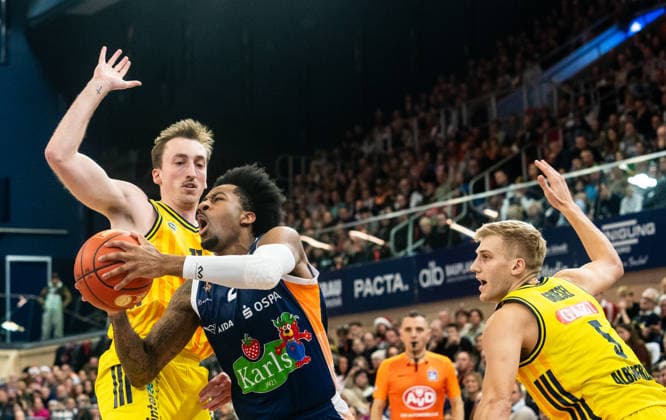 26 12 2025, Basketball, Men, easy credit BBL, easy credit Bundesliga, BBL, Bundesliga, 12 Matchday, Rostock Seawolves ALBA Berlin Moses Wood Alba Berlin, left and Sam Griesel Alba Berlin, right against Jordan Bowden Rostock Seawolves, center Rostock Stadthalle Mecklenburg Vorpommern Germany