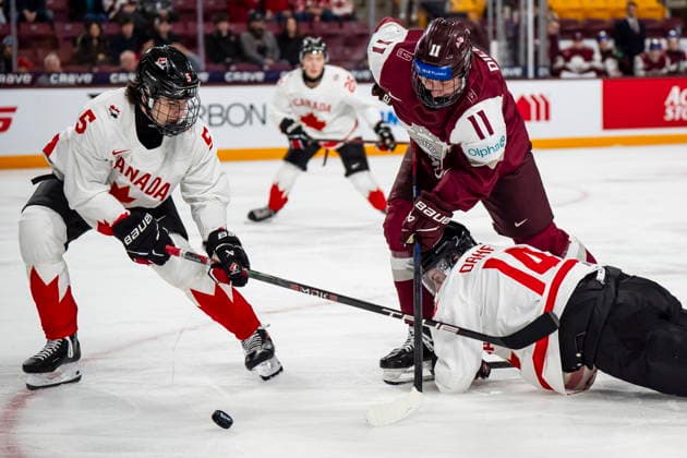 December 27, 2025, Minneapolis, Mn, Canada: Canada s Ben Danford (14) and Carson Carels (5) defend against Latvia s Dmitrijs Dilevka (11) during second period IIHF World Junior Championship hockey action, in Minneapolis, Saturday, Dec. 27, 2025. Canada News - December 27, 2025  - ZUMAc35_ 20251227_zaf_c35_086 Copyright: xChristopherxKatsarovx