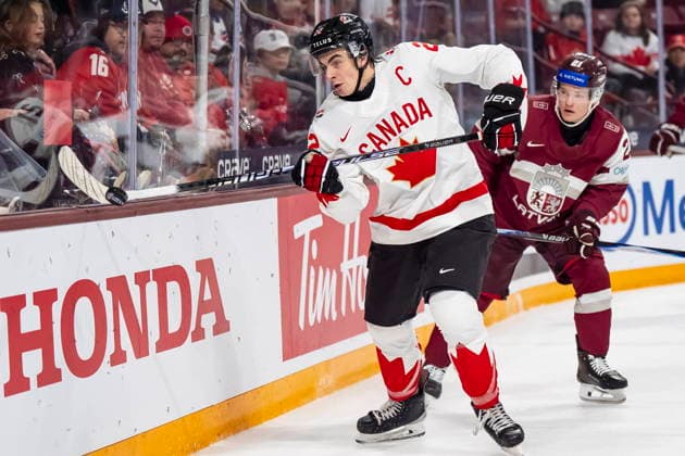 December 27, 2025, Minneapolis, Mn, Canada: Canada s Porter Martone (22) handles the puck while Latvia s Krists Retanais (21) defends behind the net during third period IIHF World Junior Championship hockey action, in Minneapolis, Saturday, Dec. 27, 2025. Canada News - December 27, 2025  - ZUMAc35_ 20251227_zaf_c35_104 Copyright: xChristopherxKatsarovx