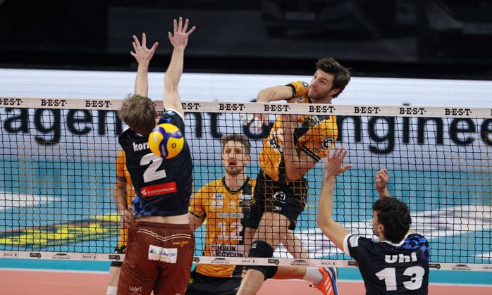 Matthew Knigge in attack, Bastian Korreck, Niklas Uhl duel Match scene Action Sport Volleyball Bundesliga Men Season 2025 2026 28 12 2025 BR Volleys Berlin BRV vs WWK Volleys Herrsching