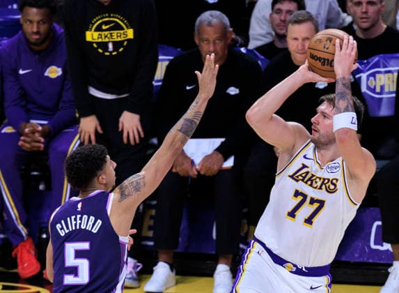 December 28, 2025, Los Angeles, California, USA: Luka Doncic 77 of the Los Angeles Lakers throws a lob as Nique Clifford 5 of the Sacramento Kings defends the basket during their regular season NBA, Basketball Herren, USA game on Sunday December 28, 2025 at Crypto.com Arena in Los Angeles, California. Lakers lose to Rockets, 96-119. ARIANA RUIZ PI Los Angeles USA - ZUMAp124 20251228_zaa_p124_027 Copyright: xArianaxRuizx