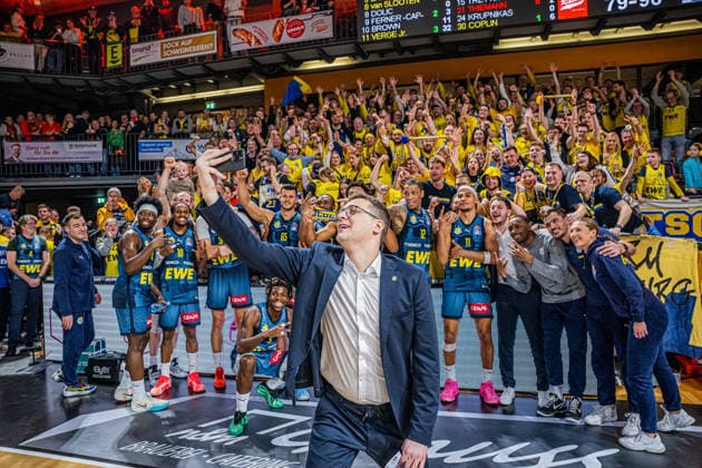 1 Basketball Bundesliga, easyCredit BBL, Season 2025 2026, Men, Main Round, Matchday 13, 29 12 2025, RASTA Vechta EWE Baskets Oldenburg Lazar Spasic Head Coach EWE Baskets Oldenburg at the victory selfie with the team and their fans Vechta RASTA Dome Lower Saxony Germany