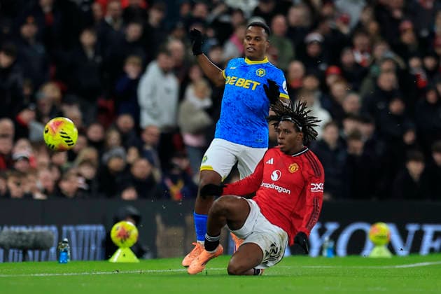 Manchester United, ManU v Wolverhampton Wanderers, Premier League Patrick Dorgu (13) of Manchester United passes the ball watched by Jhon Arias (10) of Wolverhampton Wanderers during the Premier League match between Manchester United and Wolverhampton Wanderers at Old Trafford, Manchester, UK on 30 December 2025. Manchester Old Trafford Greater Manchester UK Editorial use only DataCo restrictions apply See www.football-dataco.com , Copyright: xConorxMolloyx PSI-23486-0033