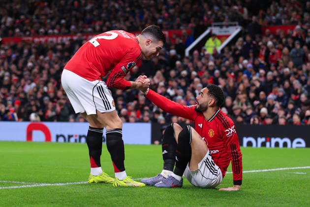 Fußball Premier League Manchester United v Wolverhampton Wanderers 30. Dezember 2025 Premier League Manchester United v Wolverhampton Wanderers Diogo Dalot von Manchester United L hilft Matheus Cunha von Manchester United auf die Beine Foto Simon Stacpoole Abseits Manchester UK  Copyright: xSimonxStacpoolexOffside