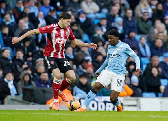 Manchester, England, 10th January 2026. Luca Woodhouse of Exeter City (l) and Ryan McAidoo of Manchester City (r) during the Manchester City vs Exeter City FA Cup match at the Etihad Stadium, Manchester. Picture credit should read: Andrew Yates Sportimage EDITORIAL USE ONLY. No use with unauthorised audio, video, data, fixture lists, club league logos or live services. Online in-match use limited to 120 images, no video emulation. No use in betting, games or single club league player publications. SPI_013_AY_Man_City_Exeter SPI-4442-0013