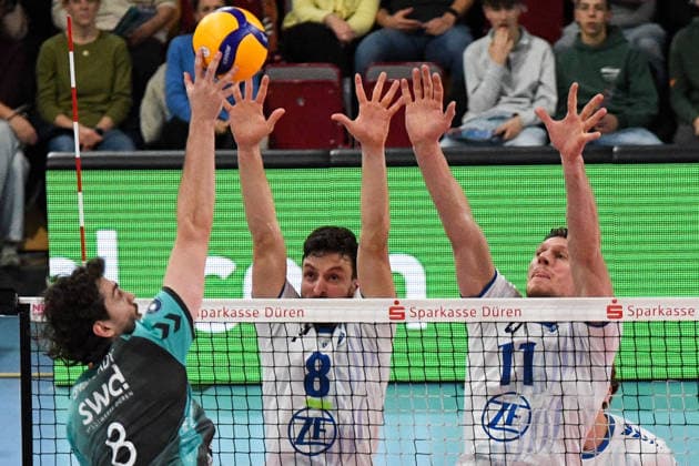 from left Robin Baghdady Powervolleys Düren, 8 smashes the ball, Aleksa Batak VfB Friedrichshafen, 8 and Marcus Böhme VfB Friedrichshafen, 11 during the block formation, , 14 01 2026, Düren Germany , Volleyball, 1 Bundesliga Men, SWD Powervolleys Düren VfB Friedrichshafen xmhx