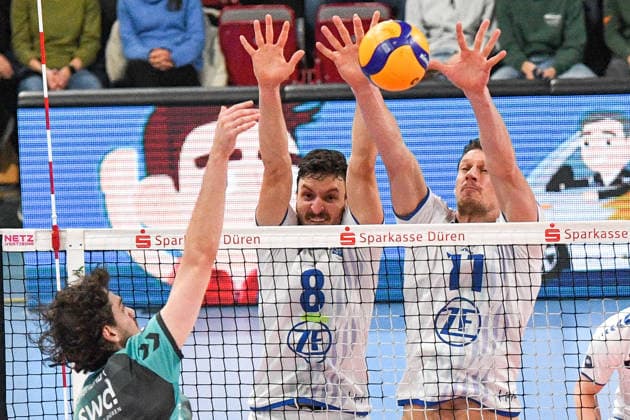 from left Robin Baghdady Powervolleys Düren, 8 smashes the ball, Aleksa Batak VfB Friedrichshafen, 8 and Marcus Böhme VfB Friedrichshafen, 11 during the block formation, , 14 01 2026, Düren Germany , Volleyball, 1 Bundesliga Men, SWD Powervolleys Düren VfB Friedrichshafen xmhx