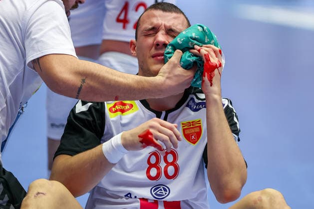 20 01 2026, Handball, Men s EHF EURO 2026, North Macedonia Romania, Jyske Bank Boxing in Herning, Denmark, Preliminary Round Pavle Atanasijevikj North Macedonia 88 sits on the court bleeding and in pain and needs medical attention Denmark