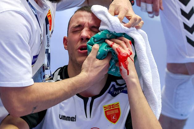 20 01 2026, Handball, Men s EHF EURO 2026, North Macedonia Romania, Jyske Bank Boxing in Herning, Denmark, Preliminary Round Pavle Atanasijevikj North Macedonia 88 sits on the court bleeding and in pain and needs medical attention Denmark