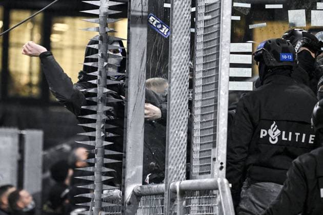 A masked Genk supporter provokes Dutch police ahead of a soccer game between Dutch soccer club FC Utrecht and Belgian KRC Genk, on Thursday 22 January 2026 in Utrecht, Netherlands, the seventh game (out of 8) in the league phase of the UEFA Europa League competition. TOM GOYVAERTS TomxGoyvaerts  x157803664x