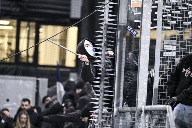A masked Genk supporter provokes Dutch police ahead of a soccer game between Dutch soccer club FC Utrecht and Belgian KRC Genk, on Thursday 22 January 2026 in Utrecht, Netherlands, the seventh game (out of 8) in the league phase of the UEFA Europa League competition. TOM GOYVAERTS TomxGoyvaerts  x157807752x