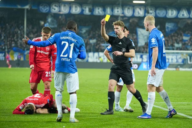 Soccer 2 Bundesliga, Matchday 19, SV Darmstadt 98 1 FC Nürnberg on 23 01 2026 in Darmstadt Merck Stadion am Böllenfalltor , Germany, Season 2025 2026 DFB DFL REGULATIONS PROHIBIT ANY USE OF PHOTOGRAPHS as IMAGE SEQUENCES and or QUASI VIDEO Jarno Wienefeld Referee shows Matondo Merveille Papela 21, SVD the yellow card after foul on Tim Janisch 32, FCN Darmstadt Merck Stadion am Böllenfalltor Germany Copyright: xChristophxKinzingerx
