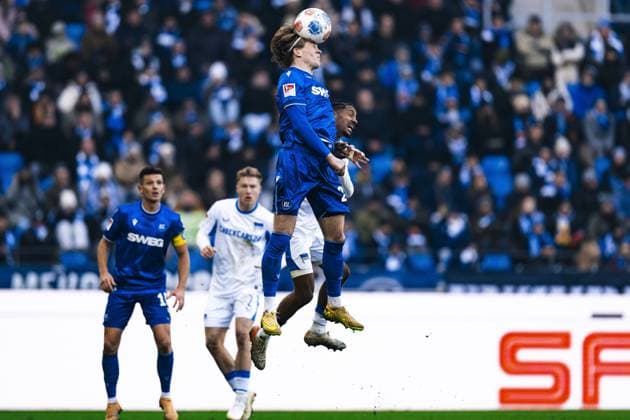 Fabian Schleusener 24 Karlsruher SC in an aerial duel for the ball against a Hertha BSC player in the background, while Marvin Wanitzek 10 Karlsruher SC observes attentively Aerial duel for the ball Copyright: xspeedshotx