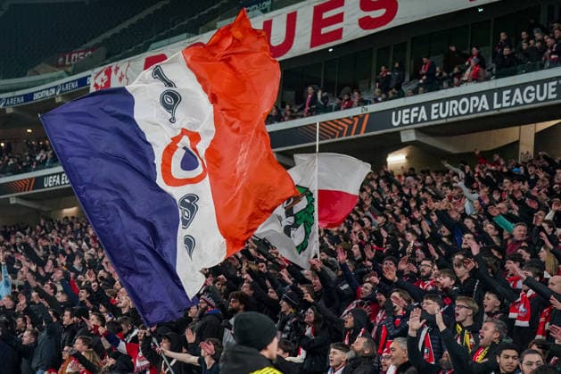 Football UEFA Europa League 2025 26, Matchday 8 OSC Lille vs SC Freiburg Stade Pierre Mauroy Lille, France Home fans of OSC Lille in the fan curve, large club flags waved in red white blue, densely packed fan block, collective cheering and raised arms, vociferous support, emotional European Cup atmosphere, UEFA Europa League branding, floodlights, grandstand view, Ultras, fan movement, home match, international soccer event, France, Europe Copyright: xJOERANxSTEINSIEKx