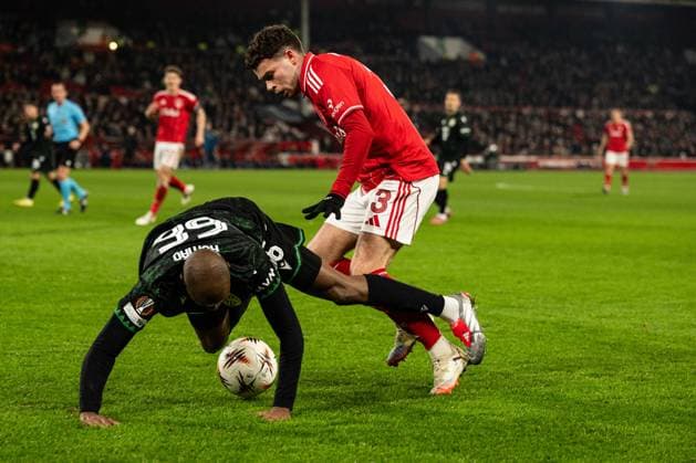 29th January 2026; The City Ground, Nottingham, England; UEFA Europa League Football, Nottingham Forest versus Ferencvarosi; Julio Romao of Ferencvarosi TC is bundled over by Neco Williams of Nottingham Forest  GodfreyxPitt Content restricted for UK based newspaper