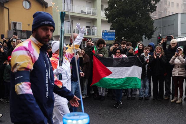 Winter Olympics - Olympic Flame Journey For Milan Cortina 2026 - Sesto San Giovanni Sesto San Giovanni, The journey of the Olympic Flame of the XXV Winter Olympic Games, Olympische Spiele, Olympia, OS Milan Cortina 2026. In the photo: The passage of a torchbearer with the Olympic Torch in front of a Palestinian flag Photo by Alessandro Bremec IPA ABACAPRESS.COM Cortina d Ampezzo Italy  Copyright: xIPA ABACAx