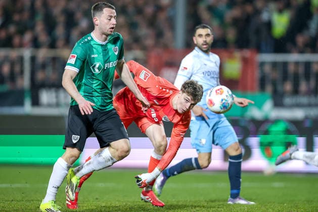 06 02 2025, Fußball, Preußen Münster VfL Bochum, 2 Fußball Bundesliga, Preußenstadion, 21 Spieltag, Saison 2025 2026 Torge Paetow Preussen Muenster 16 and goalkeeper Johannes Schenk Preussen Muenster 01 defend in the penalty area against Gerrit Holtmann VfL Bochum 17 DFB regulations prohibit any use of photographs as image sequences and or quasi video Nordrhein Westfalen Germany