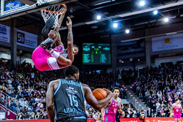 Jeff Garrett Jr Telekom Baskets Bonn, 04 hangs after a dunk at the basket, Nazihar Bohannon Science City Jena, 15 has the ball Telekom Baskets Bonn vs Science City Jena, Basketball, easy Credit BBL, 19 Matchday, 2025 2026, 07 02 2026 Telekom Baskets Bonn vs Science City Jena, Basketball, easy Credit BBL, 19 Matchday, 2025 2026, 07 02 2026 Bonn Copyright: xEibner-Pressefoto GerhardxWingenx EP_GWR