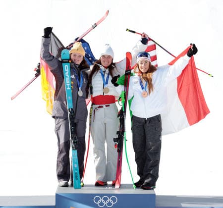 L-R Germany s Emma Aicher, USA s Breezy Johnson (C) and Italy s Sofia Goggia celebrate their medals in the Women s downhill race at the 2026 Winter Olympics in Cortina, Italy on Sunday February 08, 2026. USA s Lndsey Vonn crashed at the top of the course and was airlifted to hospital.  OLY2026020816 HUGOxPHILPOTT