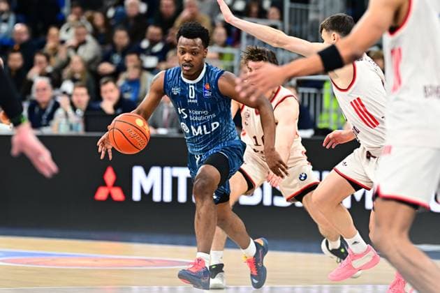 Game action with DJ Horne 0 MLP Academics Heidelberg in blue jersey on the ball, surrounded by players in white jerseys easyCredit BBL MLP Academics Heidelberg - FC Bayern München Basketball 08 02 2026 Copyright: xMichaelxGelhardtx