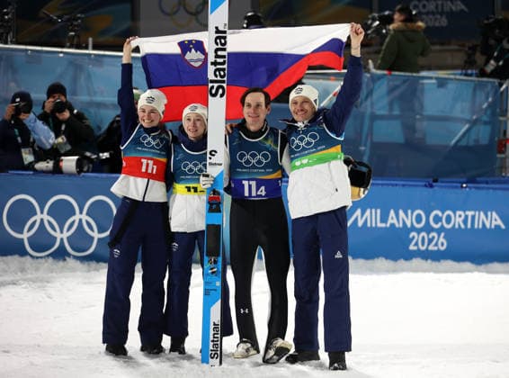 Olympische Winterspiele, Olympia, Skispringen, Mixed Team, Normalschanze, Val di Fiemme, Predazzo, Olympiaschanze Das Mixed Team von Slowenien wird Olympiasieger hier mit der Nationalfahne, VODAN Nika (SLO), Prevc, Nika (SLO) PREVC Domen (SLO), LANISEK Anze (SLO) (v.l.n.r.) *** Olympic Winter Games, Olympics, ski jumping, mixed team, normal hill, Val di Fiemme, Predazzo, Olympic ski jump The mixed team of Slovenia becomes Olympic champion here with the national flag, VODAN Nika SLO , Prevc, Nika SLO PREVC Domen SLO , LANISEK Anze SLO f l n r