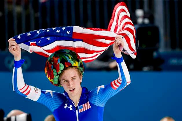 winner Jordan Stolz of United States of America celebrating and holding flag after Men 1000m, Milano Cortina 2026 Winter Olympics: Day 5, Speed skating, Eisschnelllauf - Milano Cortina 2026 Winter Olympics: Day 5, Milano Speed Skating Stadium, February 11, 2026, Milan, Italy.