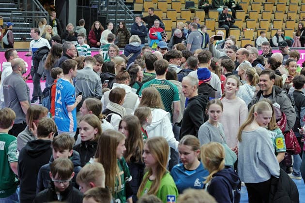 11 02 2026, xovx, Handball Daikin Handball Bundesliga, HSG Wetzlar Füchse Berlin Mathias Gidsel Superstar Füchse Berlin Well over 30 minutes after the end of the game, Nils Lichtlein Füchse Berlin stands patiently in the crowd surrounded by many young and old fans and diligently signs autographs Wetzlar Buderus Arena Hessen Germany EN